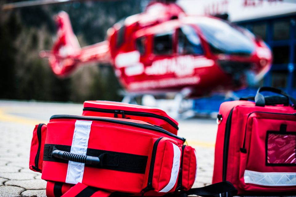 Two first aid kits with a red helicopter in the background.