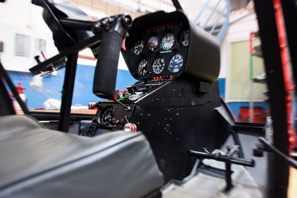 The cockpit of a helicopter with steering wheel and controls.