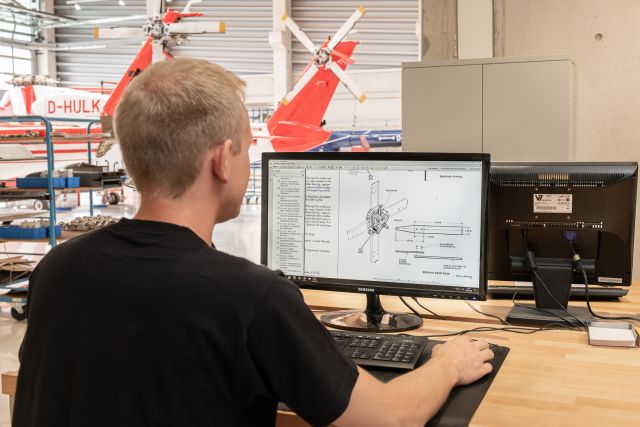 Man looks at technical drawings on the computer.