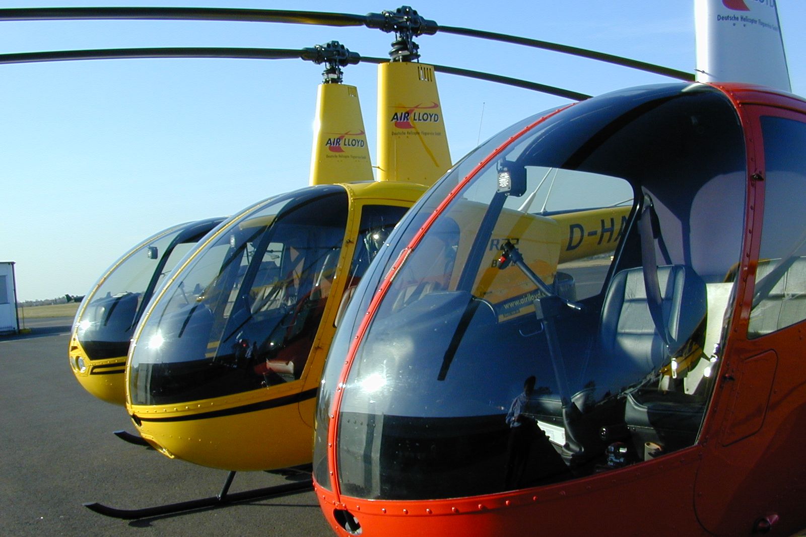 Zwei gelbe und ein roter Air Lloyd Helikopter