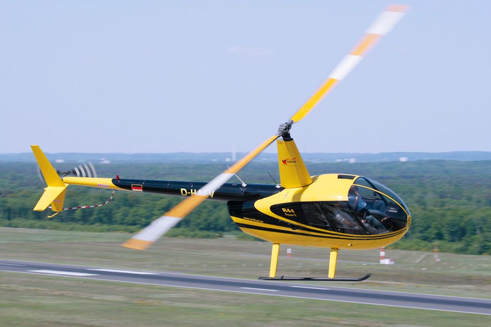 A yellow and black helicopter in the air
