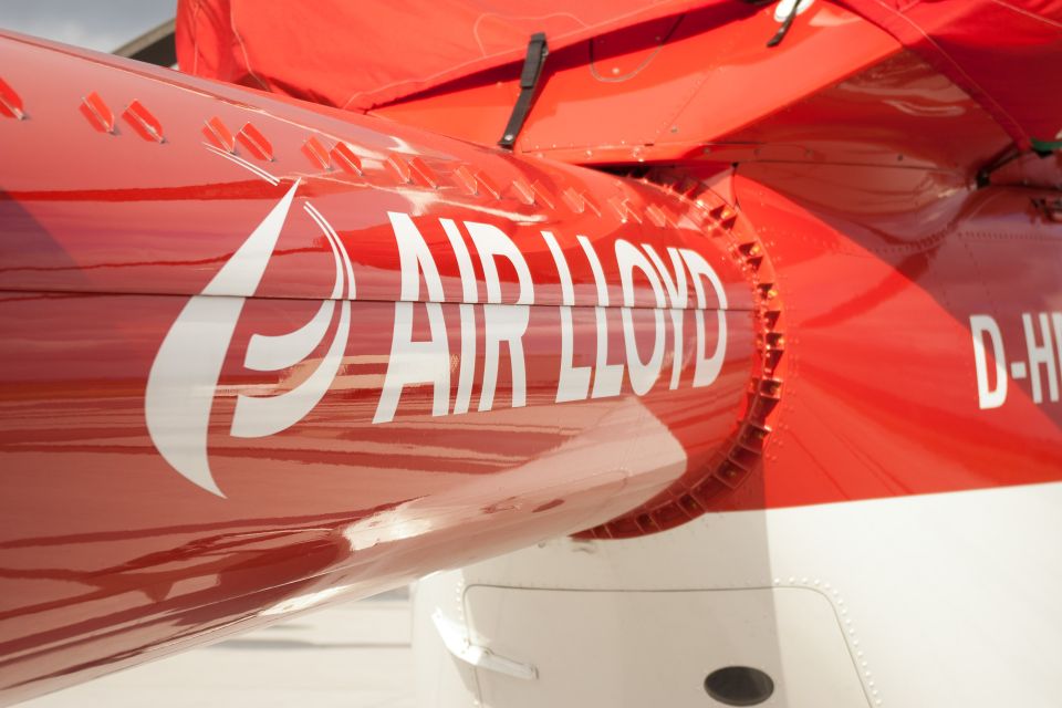 Inscription of the white AirLloyd logo on a red helicopter.