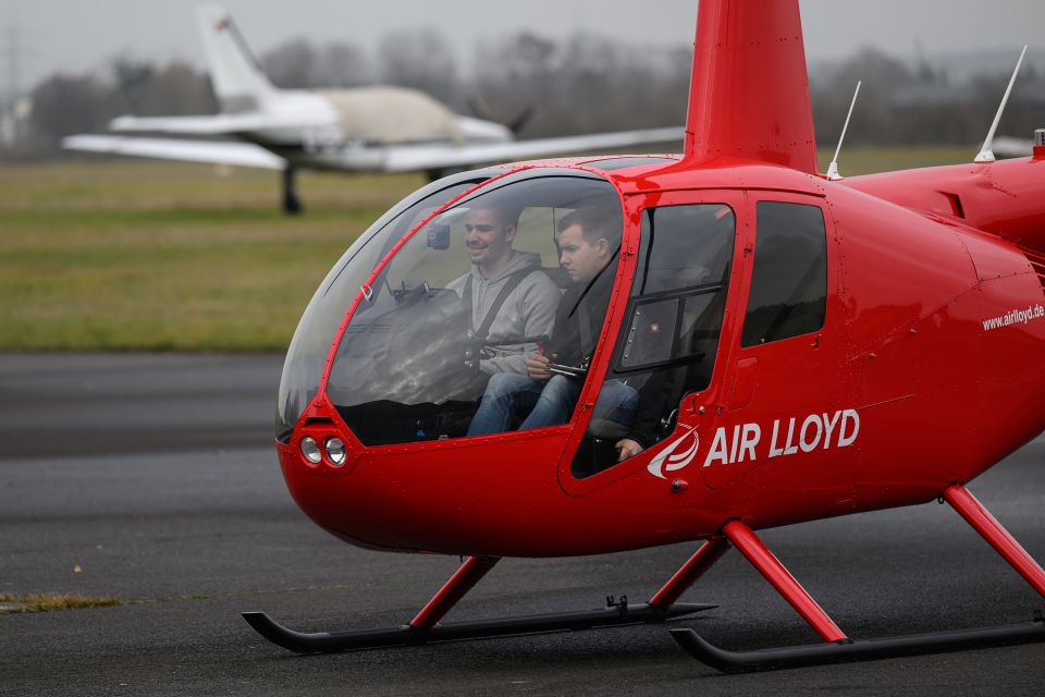 A red Air Lloyd helicopter with two people