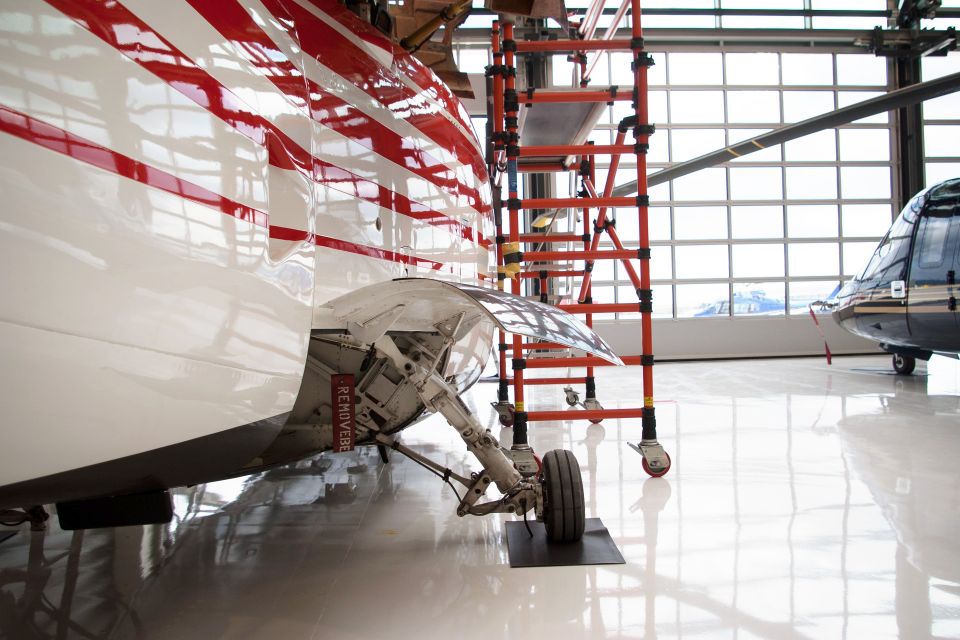 A close-up of a red and white helicopter from the side.