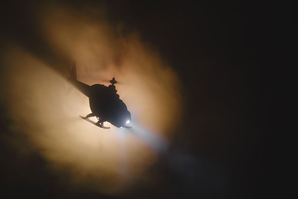 A flying helicopter at night and in fog.