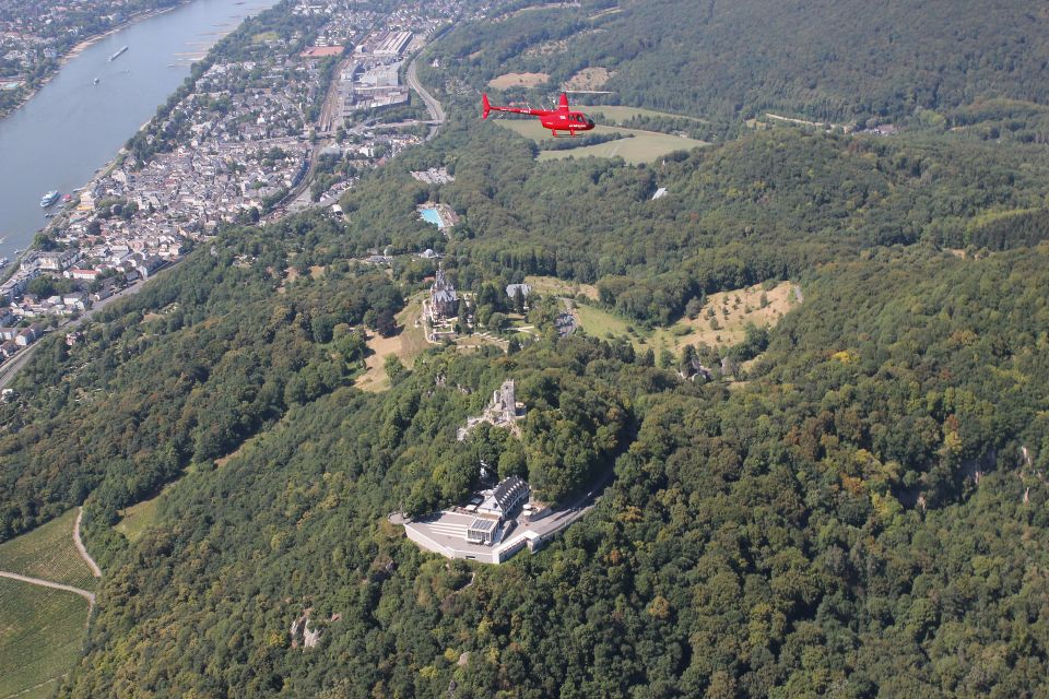 Ein roter Helikopter fliegt über das Siebengebirge.