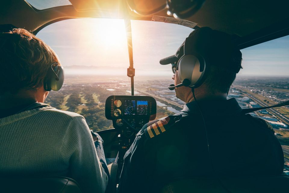 Ein Pilot und eine weitere Person im Hubschrauber in der Luft