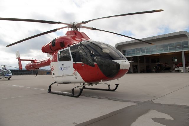 A red and white helicopter on the airfield.