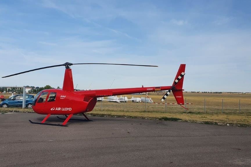 Ein roter Air Lloyd Helikopter auf dem Boden
