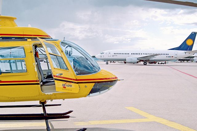 A yellow helicopter from the side with an open door.
