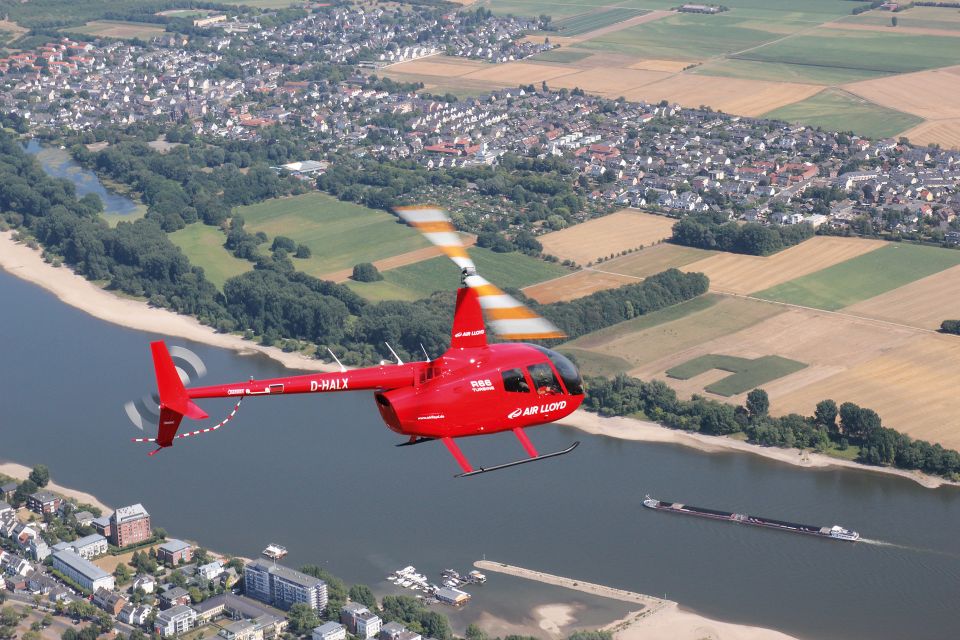 Roter AirLloyd Helikopter macht einen Rundflüg über dem Rhein.