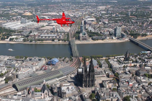 Roter Helikopter macht einen Rundflug über Köln.