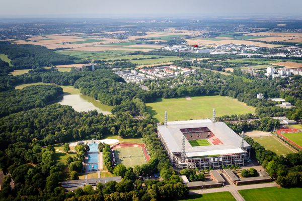 Luftaufnahme von einem Stadion in Köln umgeben von Bäumen.
